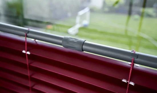 Nahaufnahme einer roten Jalousie mit grauer Halterung