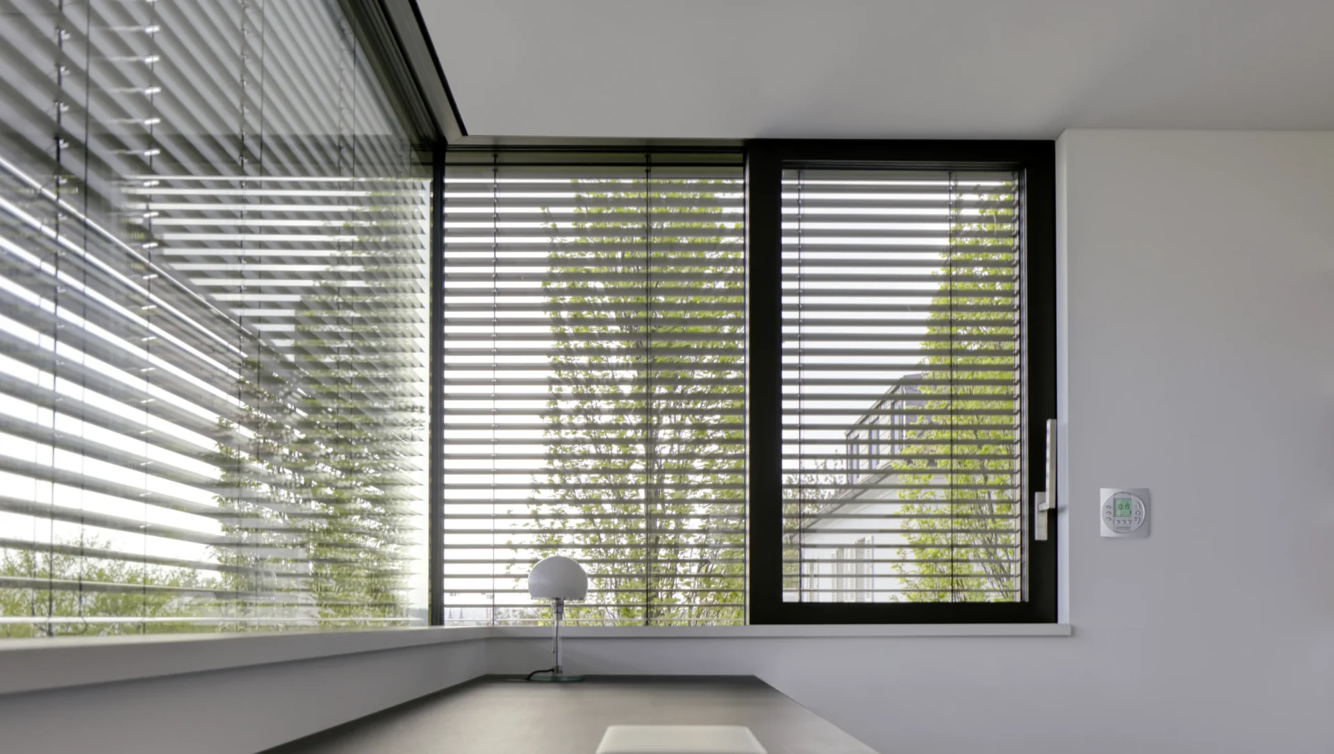 Eckfenster mit Außenjalousie und einem digitalen Thermostat