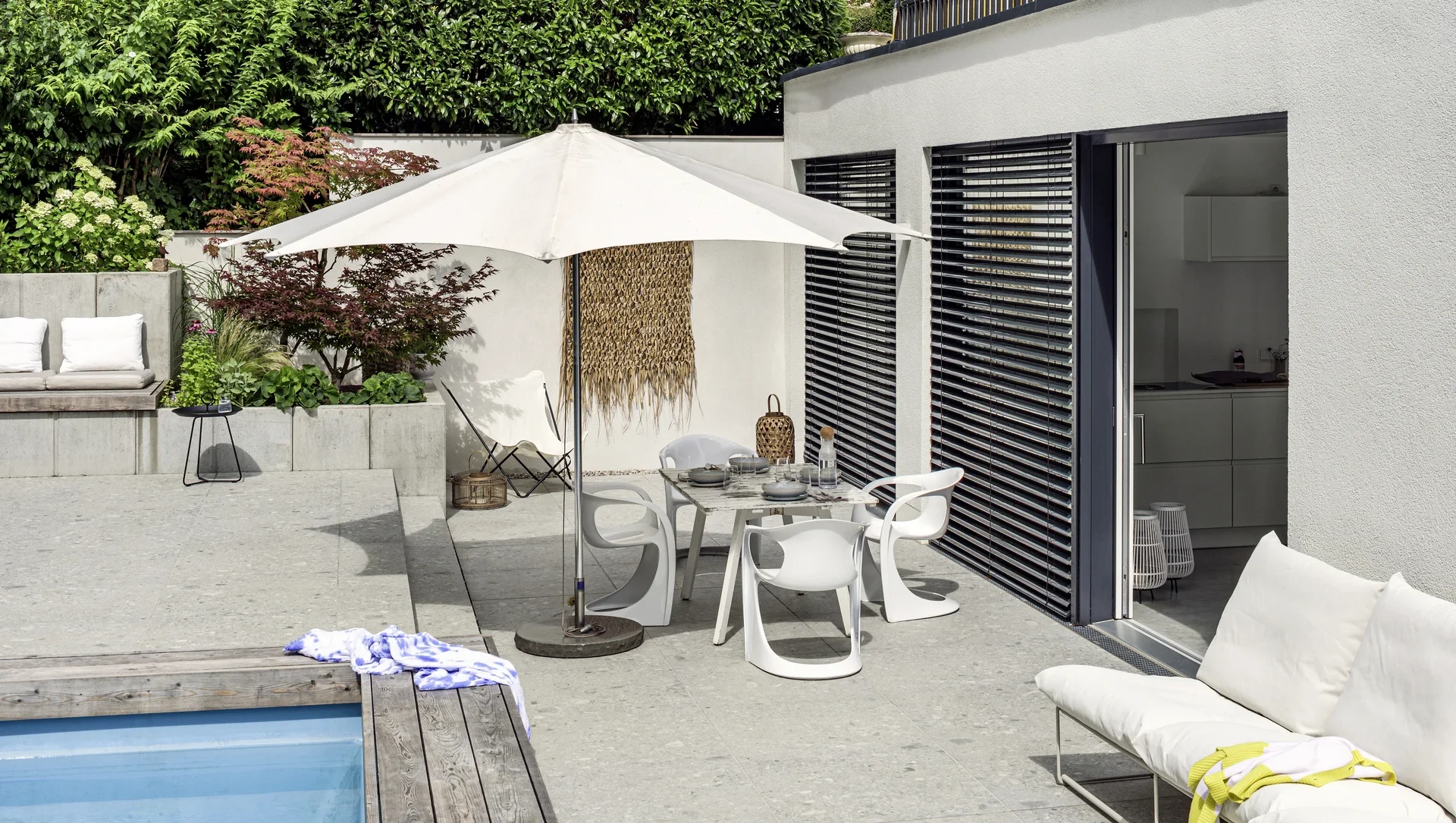 Moderne Terrasse mit Pool und stilvollen Gartenmöbeln