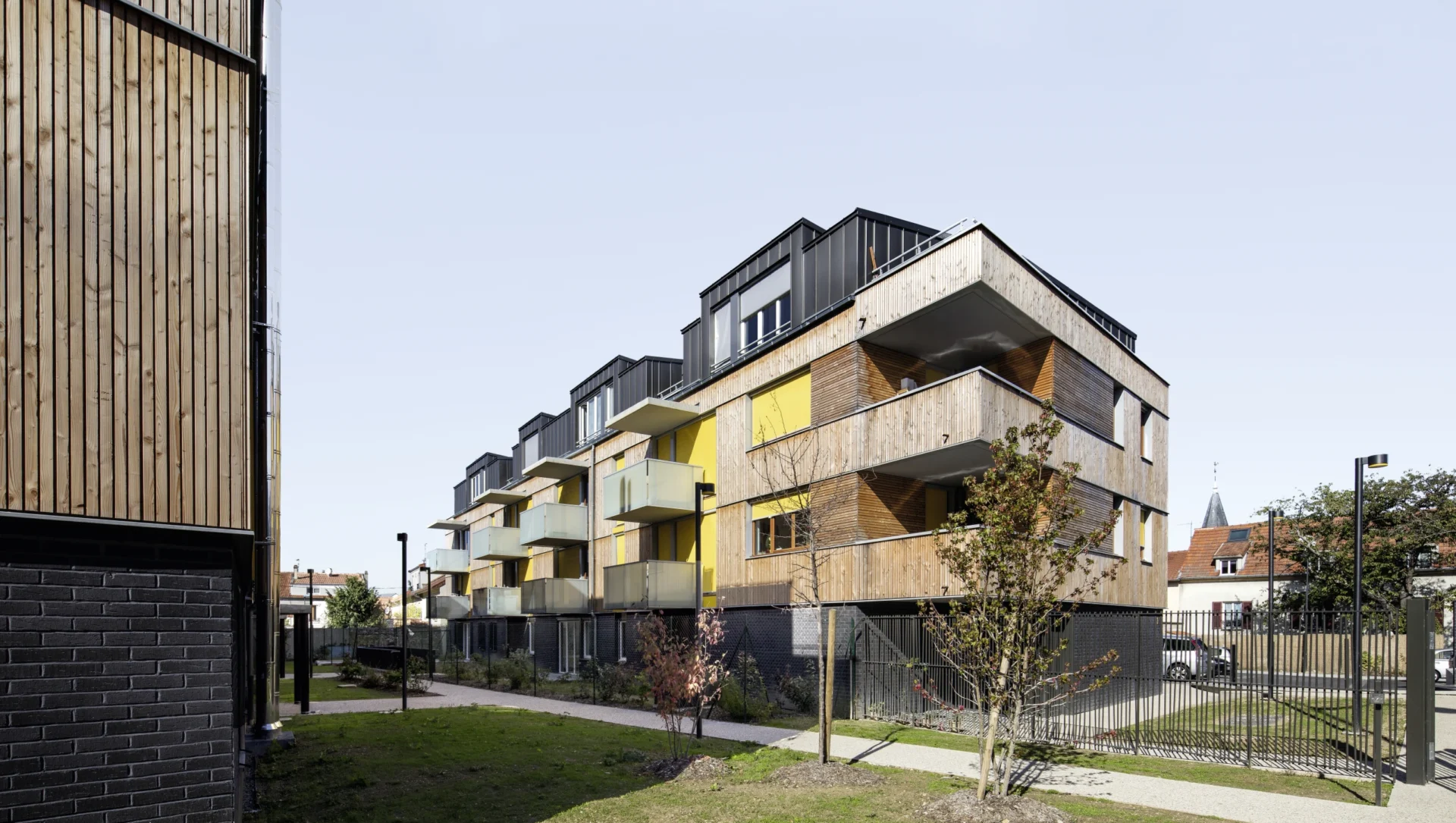 Modernes Mehrfamilienhaus mit Balkon und gelben Markisen - Basis-Markise