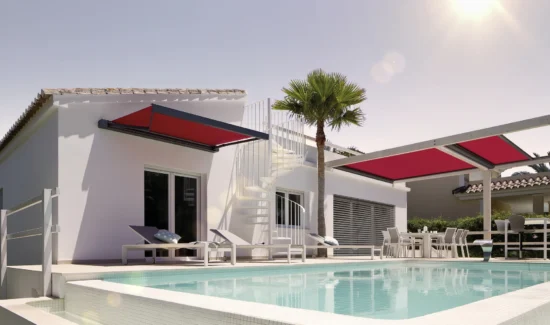 Moderne Villa mit Pool und roten Markisen bei Sonnenschein