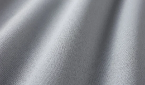 Grauer Stoff in Nahaufnahme mit weichen Falten